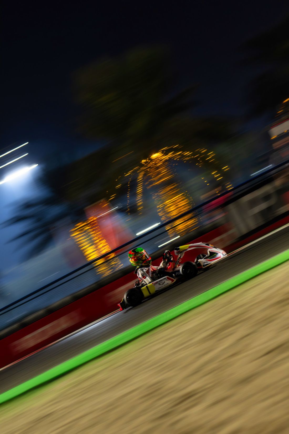 Panning shot of a kart under the lights at night
