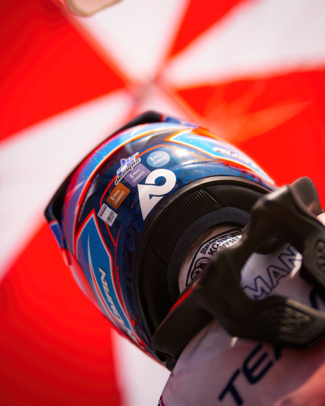 Helmet held up against a red and white umbrella