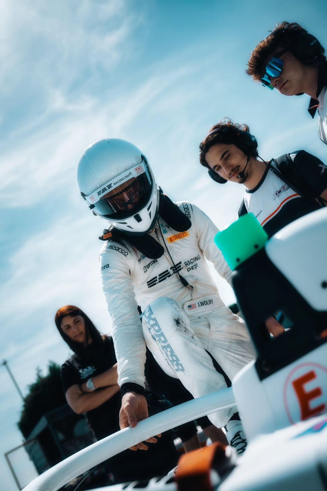 Driver climbs into the car as the crew watches