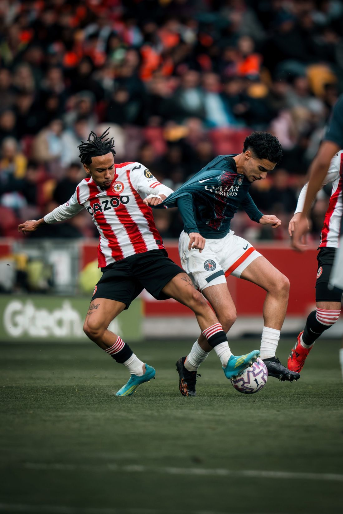 Brentford and PSG players battle for the ball