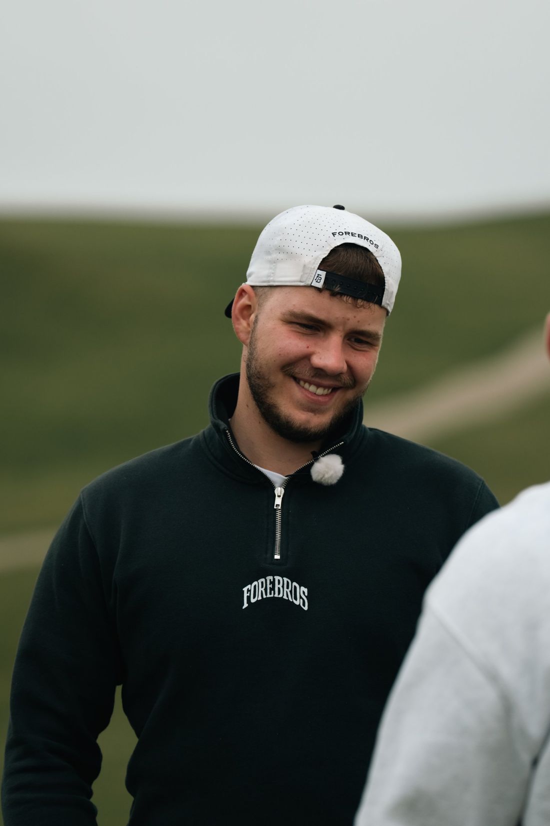 Golfer in a backwards cap smiling