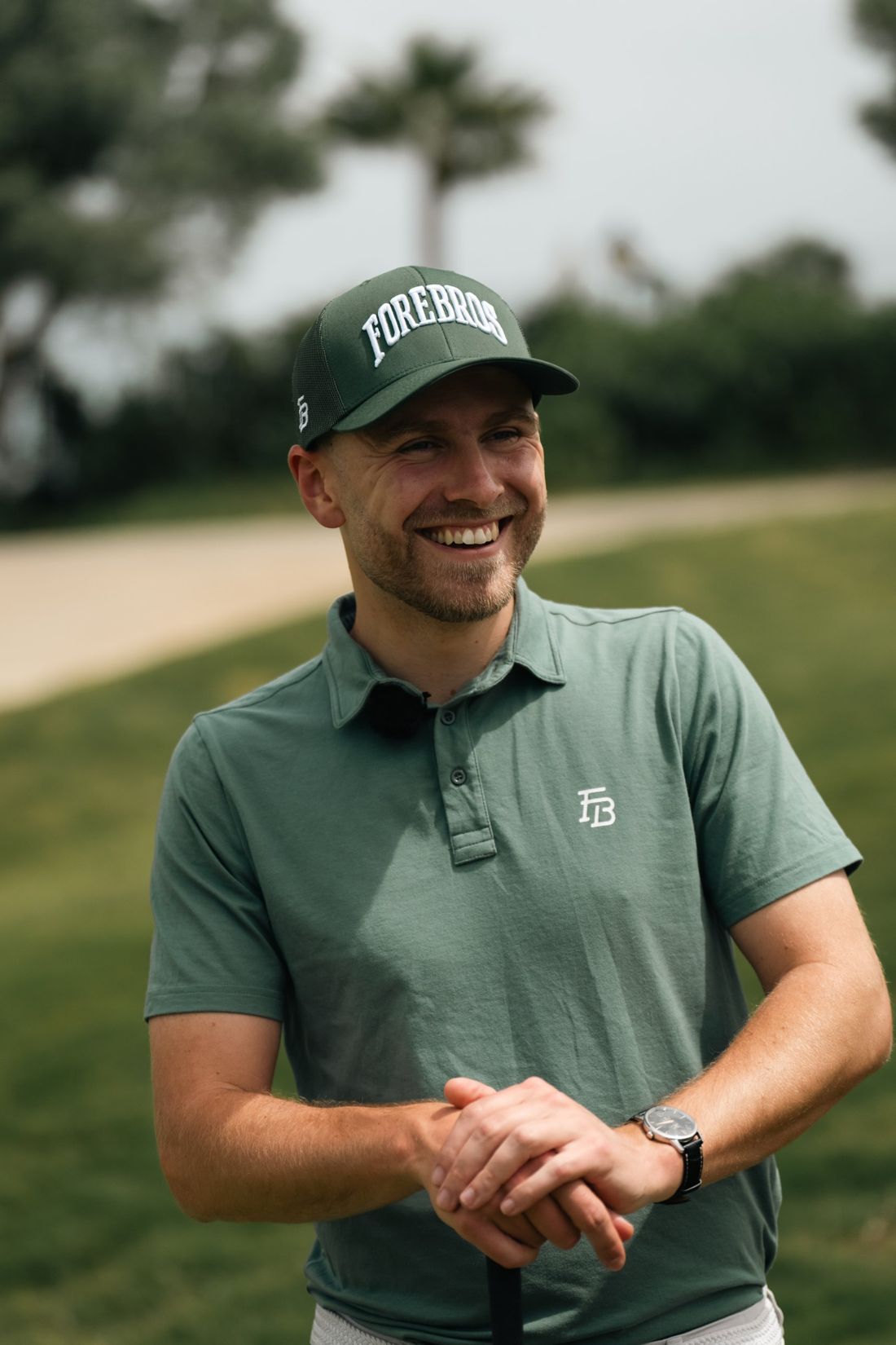 Golfer laughing in a Forebros cap