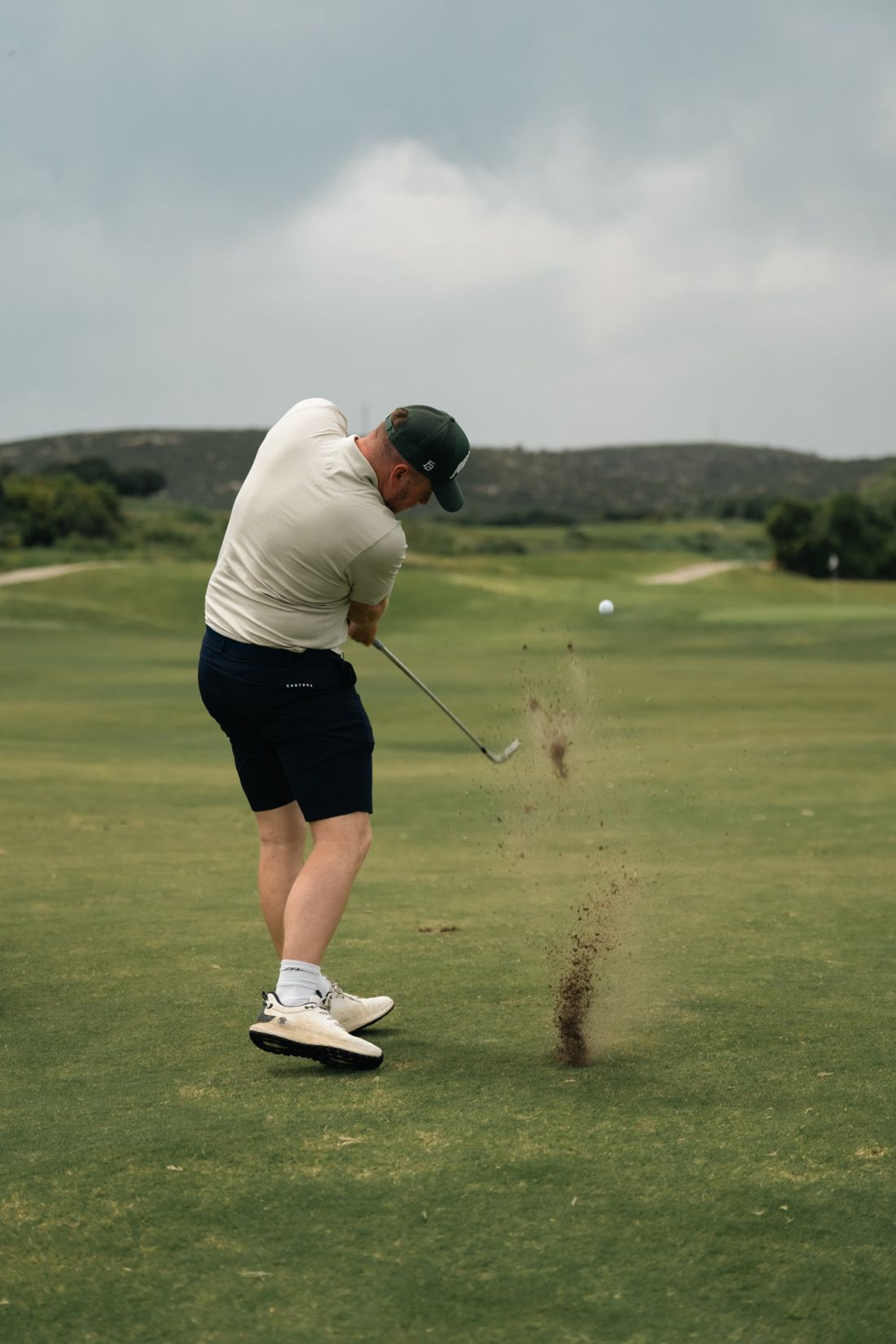 Iron shot from the fairway with divot flying