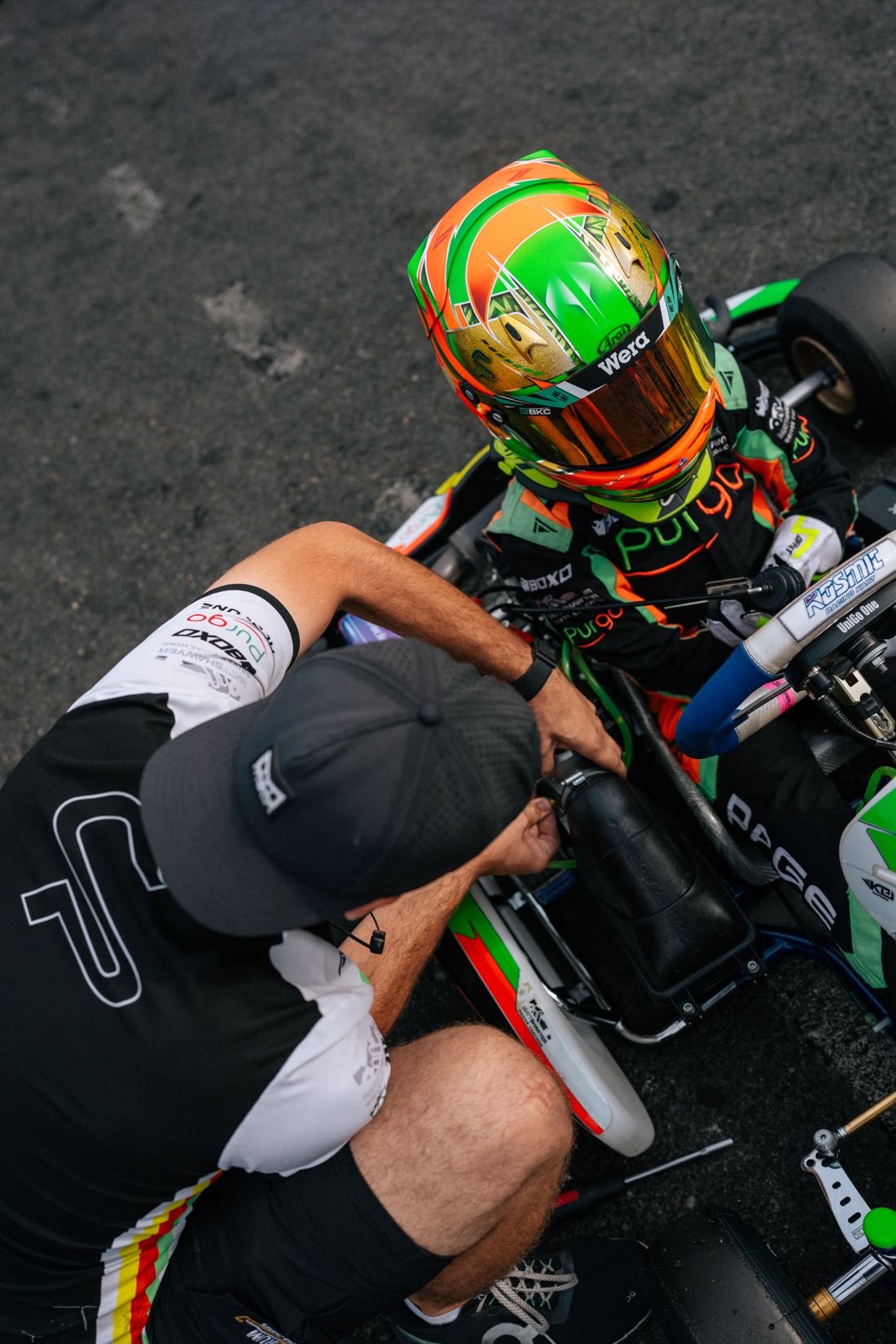Mechanic works on the kart with Charlie Page seated