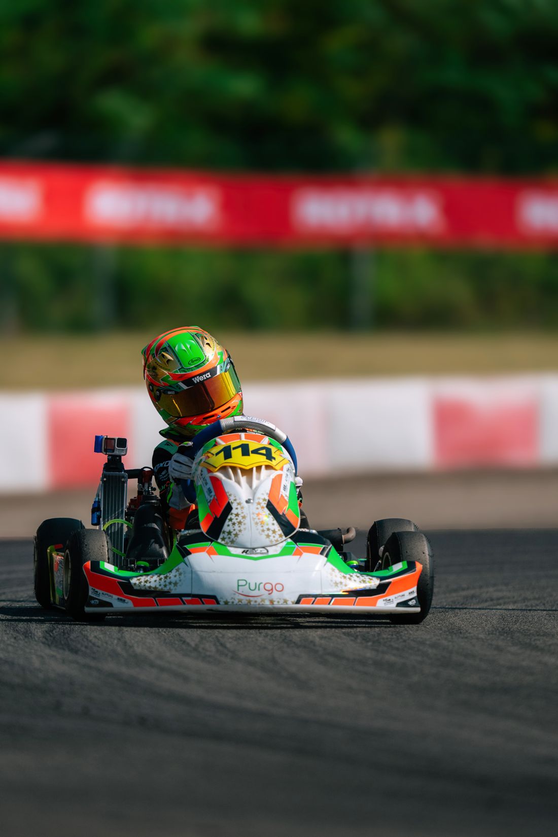 Kart 114 head-on past the kerbs