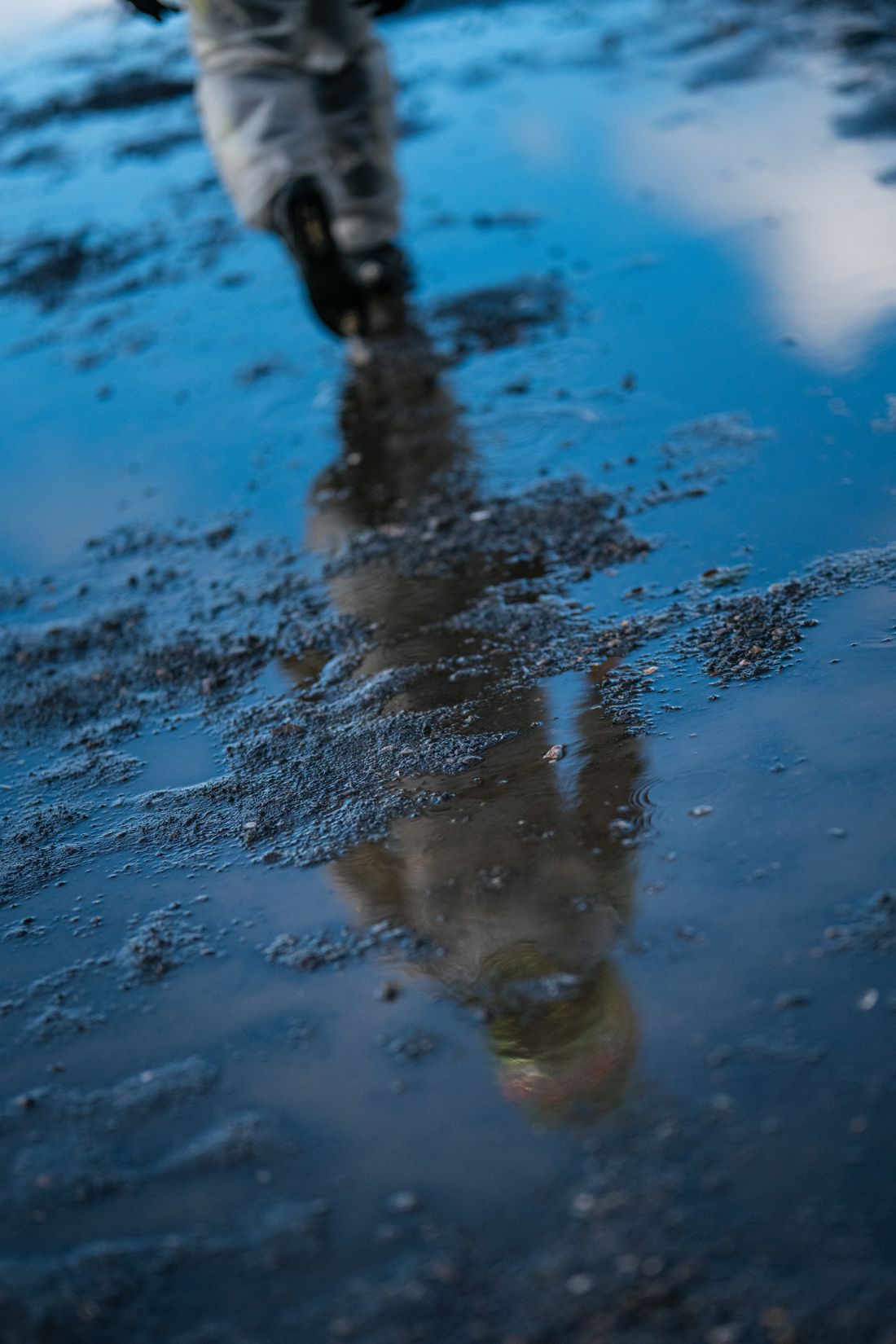 Driver reflected in a puddle on the grid